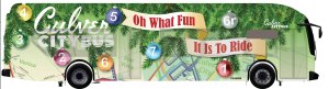 2024 Holiday Bus Graphic "Oh What Fun It Is To Ride" hints at the holiday with tree limbs and ornaments. Transit is represented the system map.